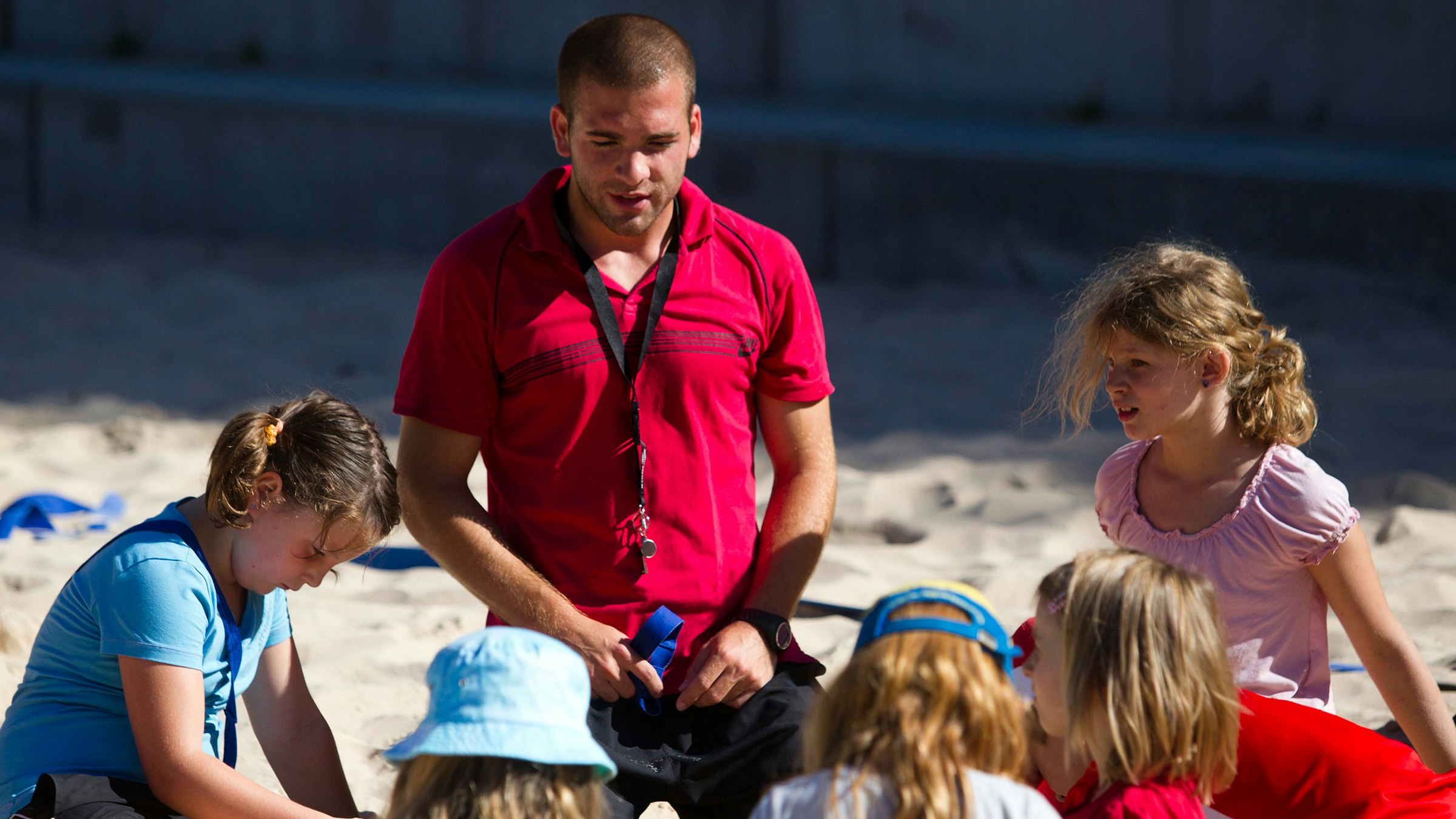 J+S-Leiter mit Kindern auf dem Beachvolleyballfeld; Foto: BASPO / Ulrich Känzig
